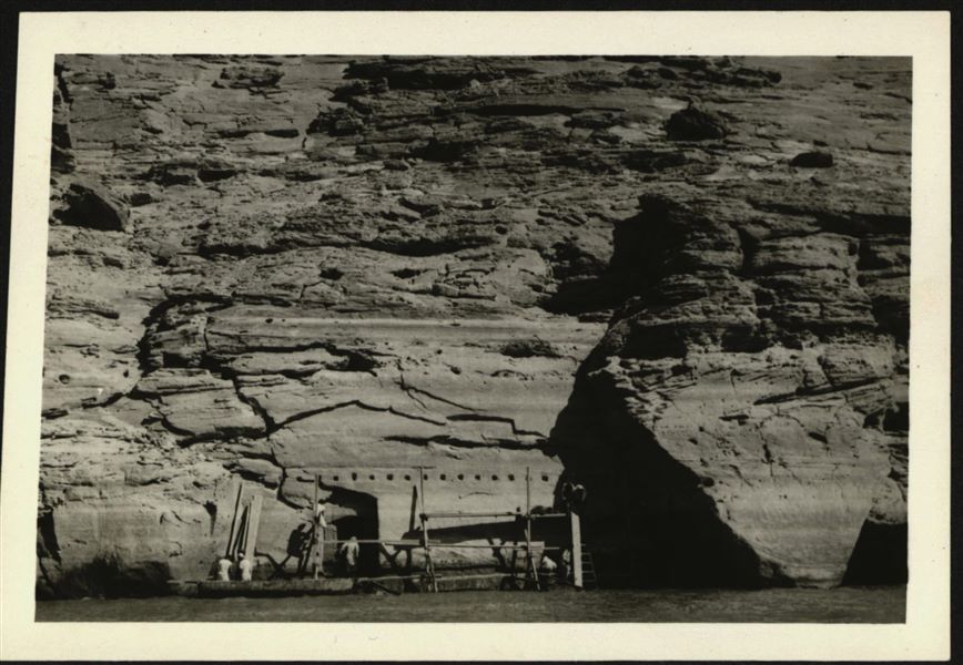 Working at the rock-cut chapel of Ellesiya. In front of the entrance there is some scaffolding that was used to remove parts of the rock-cut chapel. Note that the water level has almost reached the rock-cut chapel’s entrance, resulting in a real race against time to remove the walls, before the rising Lake Nasser submerged the entire area. 