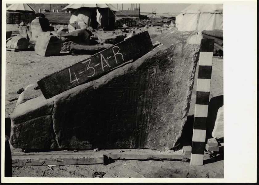 Storage at Wadi es-Sebua, one of the 66 blocks from the rock-cut chapel of Ellesiya stored waiting to be transported to Turin, after the United Arab Republic decided to gift the rock-cut chapel to the Italian Republic. Right wall of the chamber, depicting Pharaoh Tuthmosis III offering a cone shaped loaf of bread to the god Thoth, who isn’t visible on this block.  