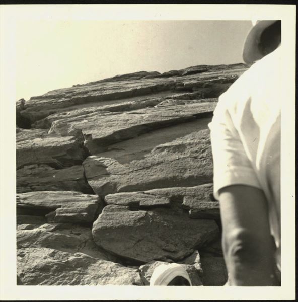 Photograph taken in front of the rock-cut rock-cut chapel of Ellesiya (the holes in the side of the rock to affix poles are notable), during the rising of Lake Nasser, which would have submerged this area. 