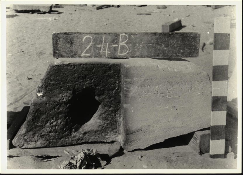 Storage at Wadi es-Sebua, one of the 66 blocks from the rock-cut chapel of Ellesiya stored waiting to be transported to Turin, after the United Arab Republic decided to gift the rock-cut chapel to the Italian Republic. Lower block from the left wall of the transverse hall, forming a corner with the left side of the back of the same transverse hall. 

