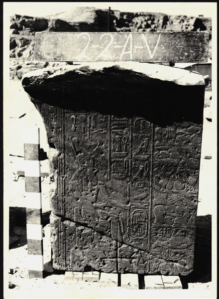 Storage at Wadi es-Sebua, one of the 66 blocks from the rock-cut chapel of Ellesiya stored waiting to be transported to Turin, after the United Arab Republic decided to gift the rock-cut chapel to the Italian Republic. Scene from the back right wall of the transverse hall, showing Horus of Miam in front of a pile of offerings. An engraving of a Christian cross can be seen at the bottom. 