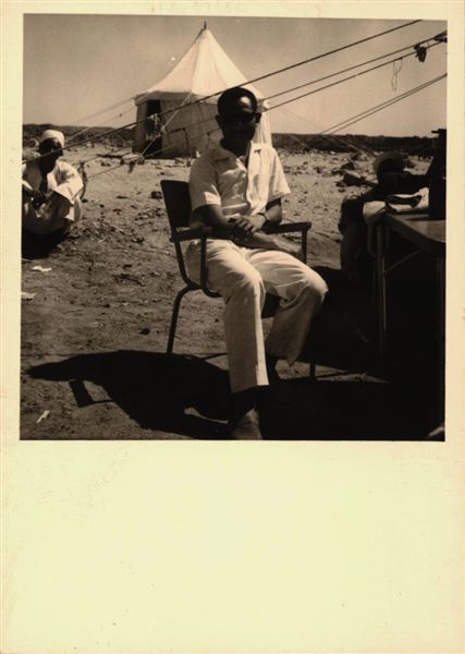 Storage at Wadi es-Sebua, where the rock-cut chapel of Ellesiya blocks were kept for a short time. Here they are arranged in rows waiting to be transferred to Turin after the United Arab Republic decided to gift the rock-cut chapel to the Italian Republic. Photographed in the centre, an inspector of the Egyptian Antiquities Service.   