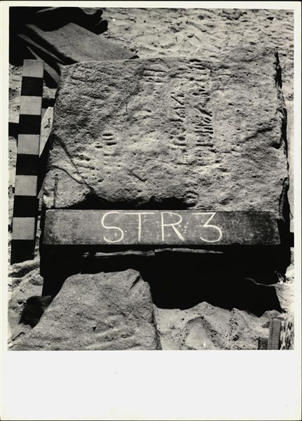 Storage at Wadi es-Sebua, one of the 66 blocks from the rock-cut chapel of Ellesiya stored waiting to be transported to Turin, after the United Arab Republic decided to gift the rock-cut chapel to the Italian Republic. One of the blocks forming part of the right side of the recess, on the rock-cut chapel's exterior façade.