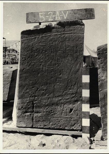 Storage at Wadi es-Sebua, one of the 66 blocks from the rock-cut chapel of Ellesiya stored waiting to be transported to Turin, after the United Arab Republic decided to gift the rock-cut chapel to the Italian Republic. This scene is located on the left wall of the transverse hall and depicts Tuthmosis III standing before of Amun-Ra. A Christian cross is clearly visible. 