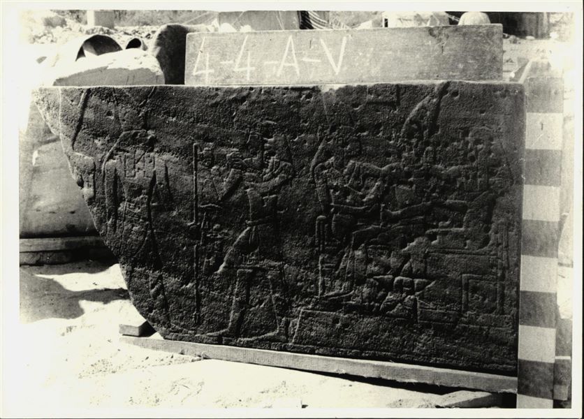 Storage at Wadi es-Sebua, one of the 66 blocks from the rock-cut chapel of Ellesiya stored waiting to be transported to Turin, after the United Arab Republic decided to gift the rock-cut chapel to the Italian Republic. Right wall of the transverse hall, showing on the left: Horus of Miam in front of Tuthmosis III, who offers wine to the deity, and on the right, the Pharaoh sits between two deities who are crowning him; the goddesses Wadjet (left) and Nekhbet (right), the “Two Ladies”, goddesses of Lower and Upper Egypt respectively. 