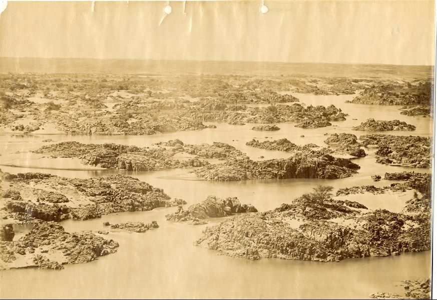 The photo shows the winding course of the Nile at the height presumably of the Second Cataract, a barrage of rocks almost impossible to pass by boat. Nowadays, the Second Cataract has been submerged by Lake Nasser, created as a result of the construction of the Aswan Dam in the 1960s. 