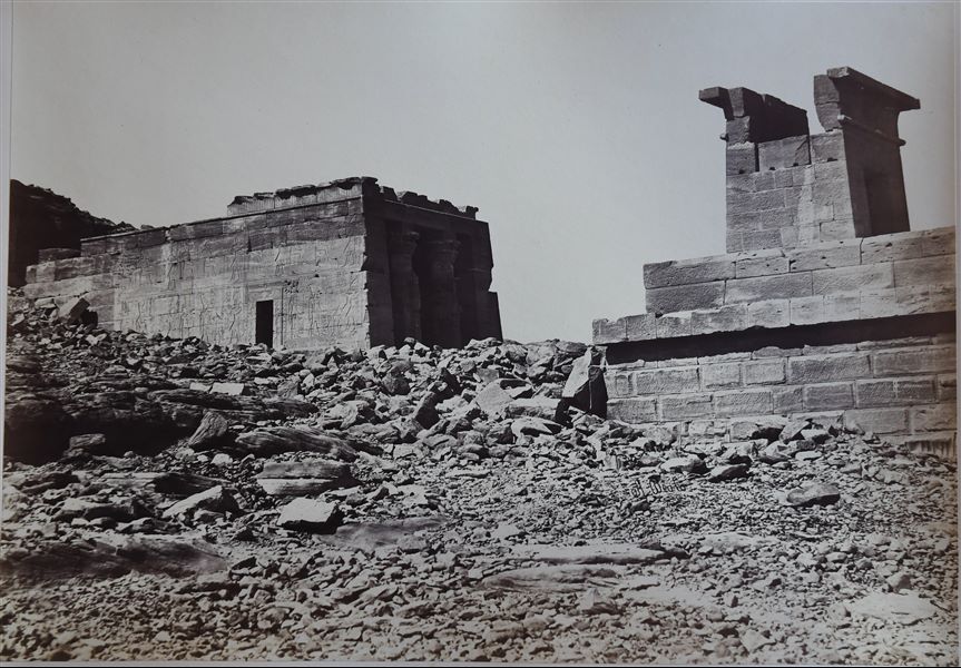 Veduta dei resti del tempio di Dendur, nella sua posizione originaria. Il tempio, a rischio sommersione in seguito alla costruzione della diga di Assuan e al nascente lago Nasser, venne rimosso nel 1963 e poi donato dal Governo Egiziano agli Stati Uniti per il loro aiuto e assistenza nell’opera di salvataggio dei templi nubiani e documentazione del territorio, ed è oggi all’interno del Metropolitan Museum of Art (The MET), a New York. In basso a destra, la firma dell’autore. 