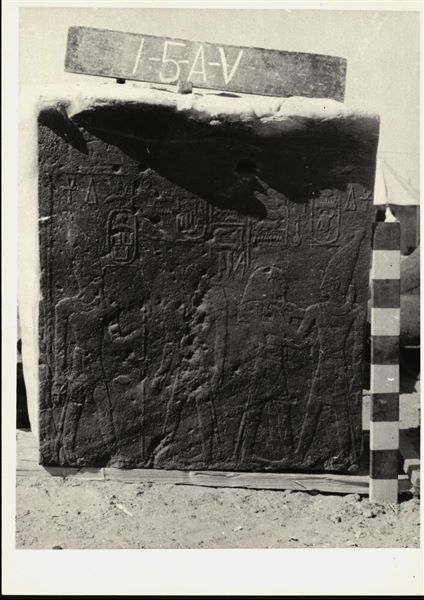 Storage at Wadi es-Sebua, one of the 66 blocks from the Temple of Ellesiya stored waiting to be transported to Turin, after the United Arab Republic decided to gift the temple to the Italian Republic. Wall scene to the right of the transverse hall’s entrance, and depicted from left to right are: Sesostris III wearing the white crown, worshipped by Thutmosis III, and the god Dedun embracing Thutmosis III wearing the white crown. A Christian cross is also visible. 