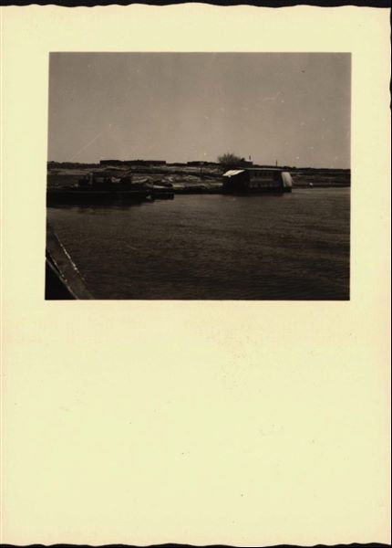 Photograph taken in the area of the site of Ellesiya, when Lake Nasser had already formed and was full. There are some boats for the transport and accommodation of the people who were working on the rock-cut Temple of Ellesiya. 