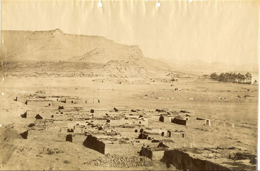 La fotografia mostra il paesaggio agricolo presso un villaggio, verosimilmente dell'area tebana. La firma dell’autore si trova in basso a sinistra.