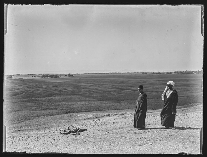 Paesaggio egiziano rappresentante un’ampia pianura. Sullo sfondo, sotto la montagna più alta, si individuano alcune rovine in un contesto urbano, da identificarsi presumibilmente con i resti del tempio di Luxor.