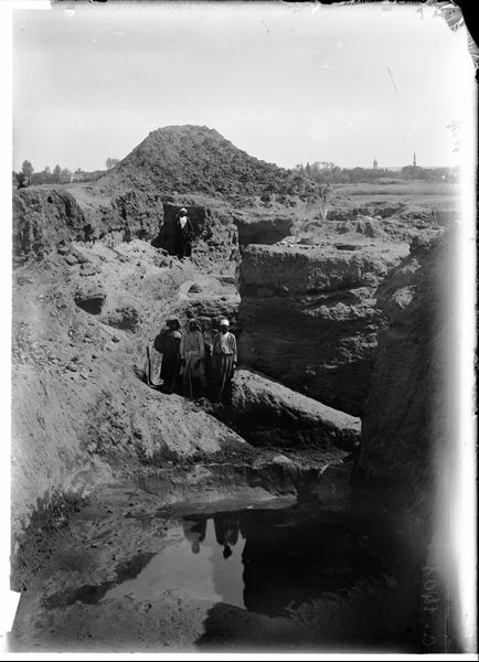 Excavating in the south-east area of the sacred enclosure; trench in the area of a historic building. Curiously, the presence of an umbrella can be noted. Schiaparelli excavations.