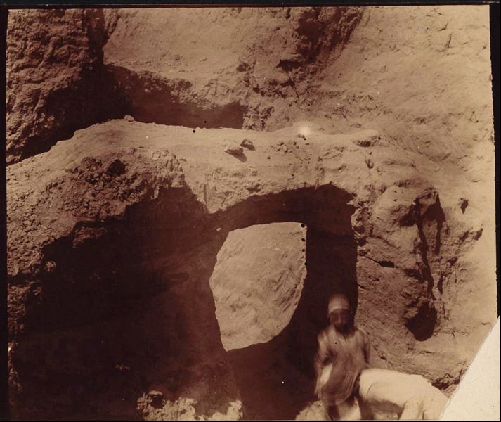 Excavation trench in the Kom area, where a bridge structure can be seen. The two young workers are out of focus, probably because they are moving. Schiaparelli excavations.