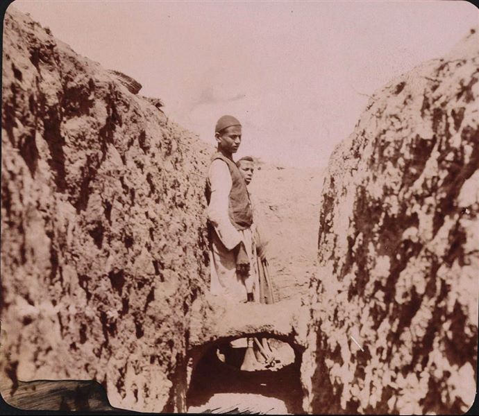 Fotografia dello scavo di una trincea che ha messo in luce i resti di un’antica struttura. Scavi Schiaparelli.