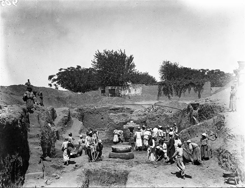 Trench in kom, with “late period” columns. In the foreground, excavation of a trench up until the prehistoric level. In the background, Arabic houses.  Schiaparelli excavations. 