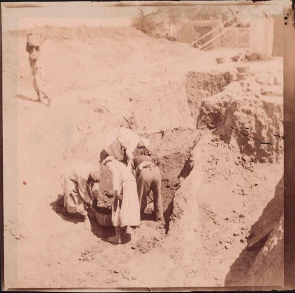 Excavation trench in the area of the Sun Temple. In the background is the wall of Latif’s house. Latif was an Egyptian man who owned a house and land in Heliopolis. Photograph overexposed and in sepia. Schiaparelli excavations.