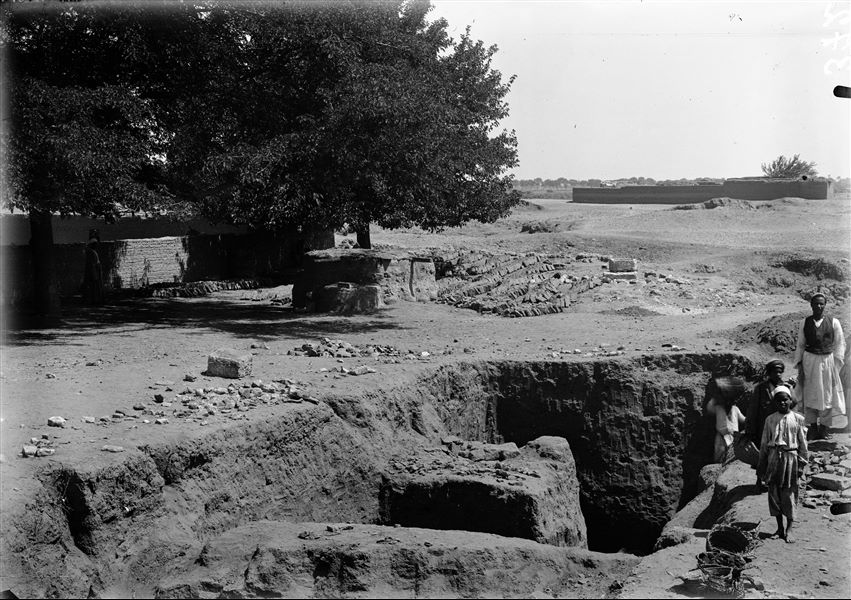 Excavations in the Bey field in the kom area, near a saqiyah. Some houses are visible in the background, probably from kom. Schiaparelli excavations.