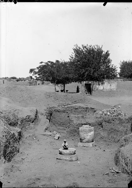 Trench in kom, with “late period” columns. In the background, Arabic houses also near Kom. Schiaparelli excavations.