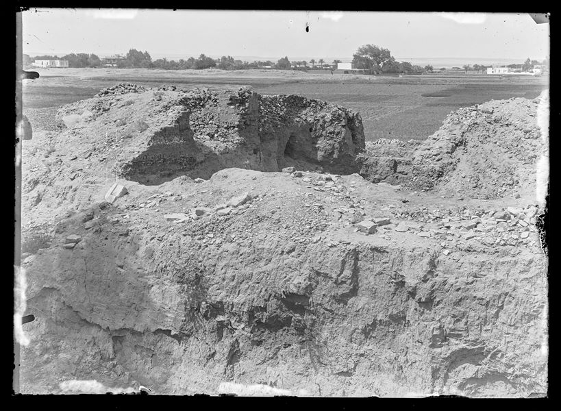 Trincea di scavo a Eliopoli. Sullo sfondo dopo la pianura si riconoscono alcune costruzioni circondate dalla vegetazione. Scavi Schiaparelli. 
