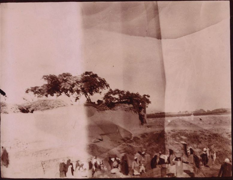 Tempio di Mnevis, trincea con frammenti del naos di Psammetico, a ridosso delle abitazioni. La stampa su carta è stata virata con il color seppia.  Scavi Schiaparelli.