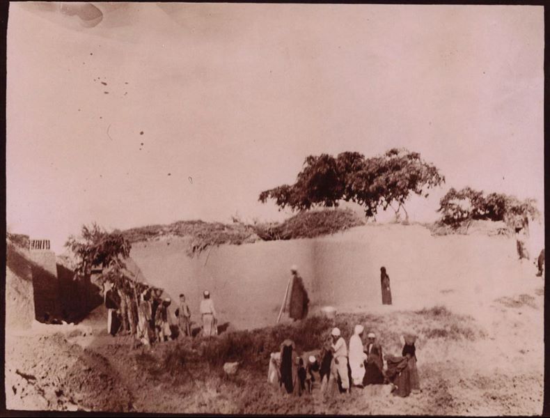 Tempio di Mnevis, trincea con frammenti del naos di Psammetico, a ridosso delle abitazioni. La stampa su carta è stata virata con il color seppia. Scavi Schiaparelli.