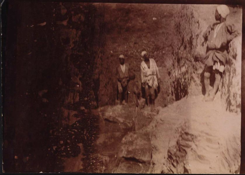Momento di scavo all’interno di una trincea, con il l’affioramento dalla terra di alcuni blocchi lavorati. Scavi Schiaparelli.