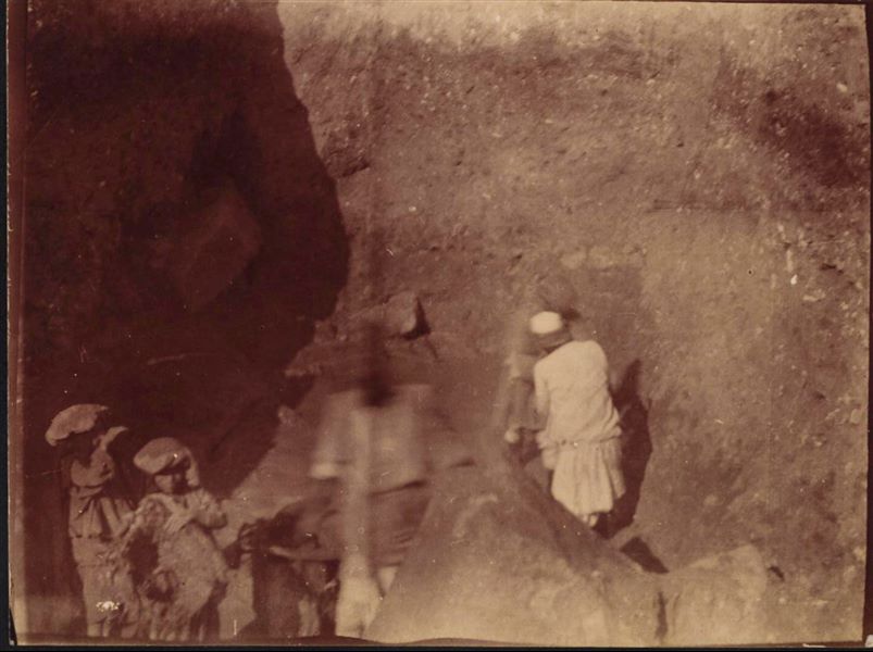 Excavating inside a trench, with some blocks surfacing from the earth. Schiaparelli excavations.