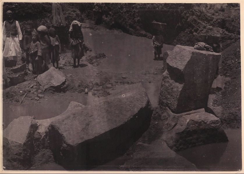 Tempio di Mnevis, trincea con frammenti del naos di Psammetico. Da notare il terreno fangoso. La stampa su carta è stata virata con il color seppia. Scavi Schiaparelli.