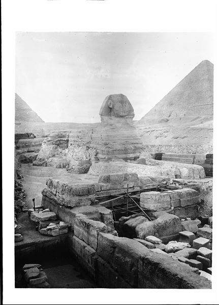View of the sphinx, on the right the pyramid of Cheops, on the left the pyramid of Chefren. In the foreground, the remains of the funerary temple of Chefren. Schiaparelli excavations.