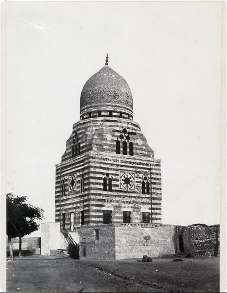 Detail of a mausoleum in the Islamic cemetery, built with alternating light coloured and red stones, near Cairo. The author's signature can be found at the bottom left. 