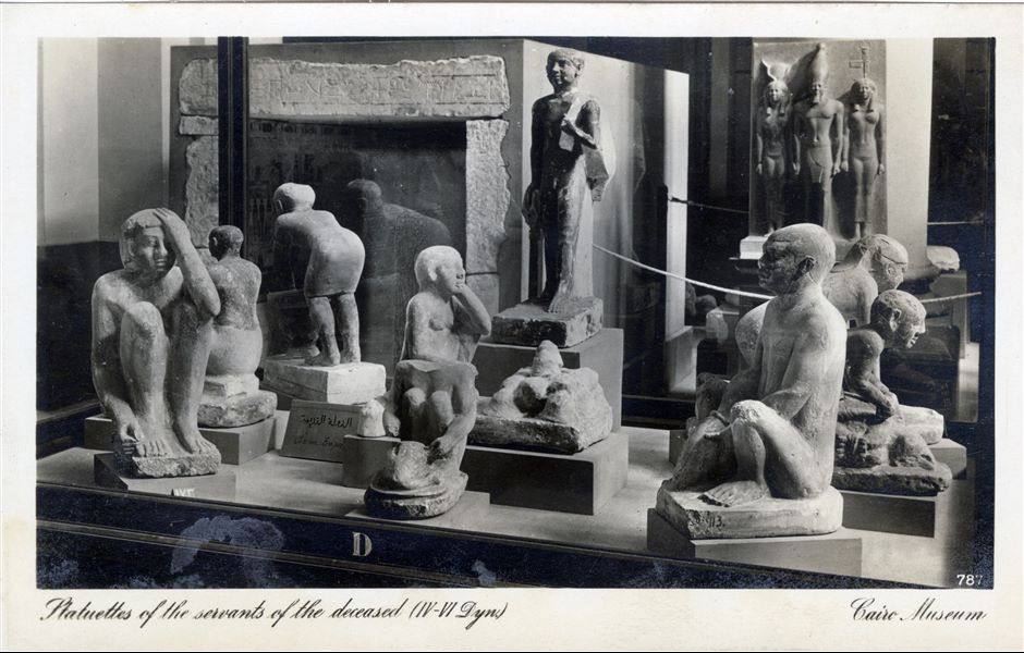 Gallery in the Egyptian Museum in Cairo. Display case with statuettes of servants, datable to the Old Kingdom. Album “Cartes postales” (Postcards).