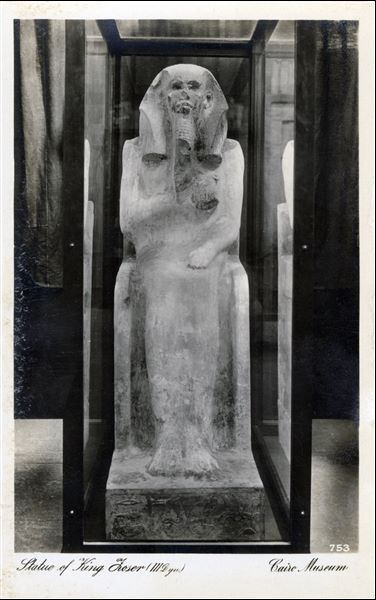 Gallery in the Egyptian Museum in Cairo. Intact statue of the Ka of Pharaoh Djoser, the first pharaoh of the 3rd dynasty. This oldest known to be made life size statue was discovered during excavations in 1924-25 in the serdab (sealed chamber in the tomb of the deceased designed to house the statue of the Ka) of the ruler's step pyramid at Saqqara. Album “Cartes postales” (Postcards).