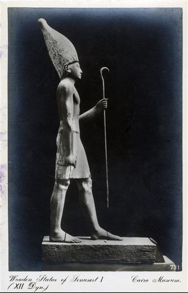 Gallery in the Egyptian Museum in Cairo. Wooden statue of Pharaoh Sesostris I, 12th dynasty, wearing the White Crown of Upper Egypt. Found in Lisht in 1914. Album “Cartes postales” (Postcards).