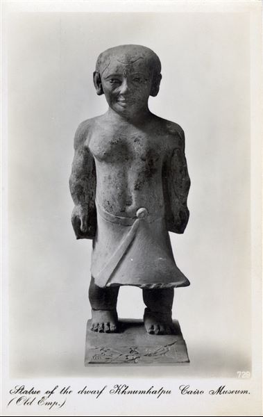 Gallery in the Egyptian Museum in Cairo. Statue of the dwarf Khnumhotep (Cairo CG 144), from the Old Kingdom (5th or 6th dynasty), found at Saqqara. Album “Cartes postales” (Postcards). 