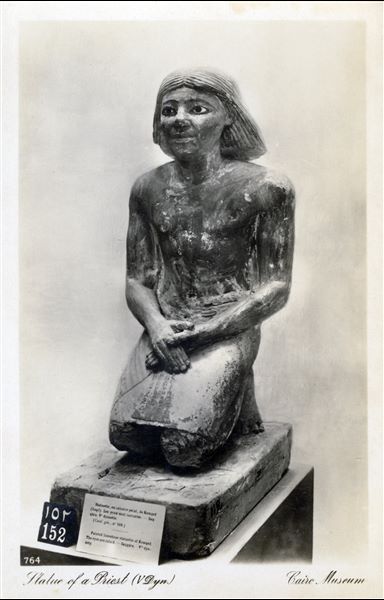 Sala del Museo Egizio del Cairo. Statua del dignitario Kaemqed, inginocchiato, risalente alla V dinastia. La statua fu trovata a Saqqara (Cairo CG 119). Album “Cartes postales”. 