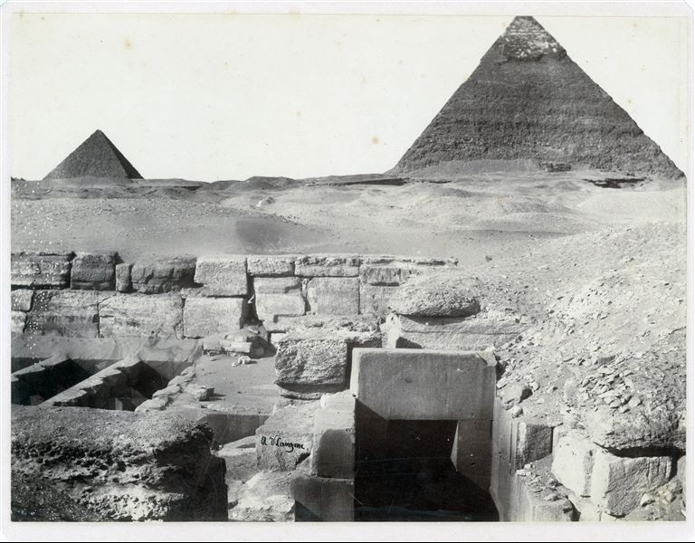 Photograph of the remains of the Valley Temple of Pharaoh Khafre, whose pyramid can also be seen. On the left, the pyramid of Menkaure, the third largest one. The author's signature can be found in the bottom centre.