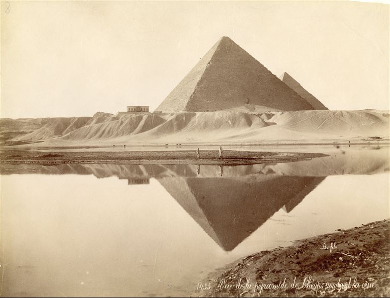 The pyramid of Pharaoh Khufu and the pyramid of Pharaoh Khafre (partially visible, behind that of Khufu) are reflected in the water during a flood. As a result of construction and damming works, the water no longer reaches the pyramids today. The author's signature is visible at the bottom right.