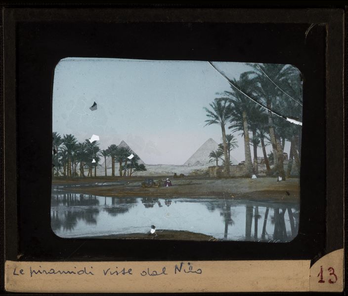 The pyramids seen from the Nile. The image is in colour and is probably a 19th century photo.