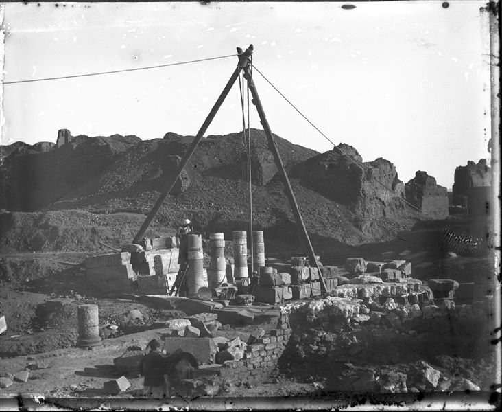  Restoration work on the colonnade in the Ashmunein excavation area. Two Egyptian workmen can also be seen engaged in activity. Schiaparelli excavations.