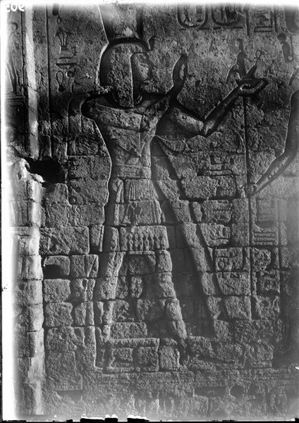 Left side of the entrance portal of the temple of Amun (and Thoth) inside the sacred enclosure of the temple of Thoth. Pharaoh Seti II can be recognised, and on the right, the figure of the god Thoth. Schiaparelli excavations.