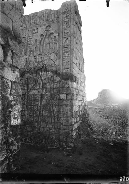 Left side of the entrance portal of the temple of Amun (and Thoth) inside the sacred enclosure of the temple of Thoth. The god Thoth can be recognised, and on the left, the figure of pharaoh Seti II. Photograph taken from inside the temple. Schiaparelli excavations.