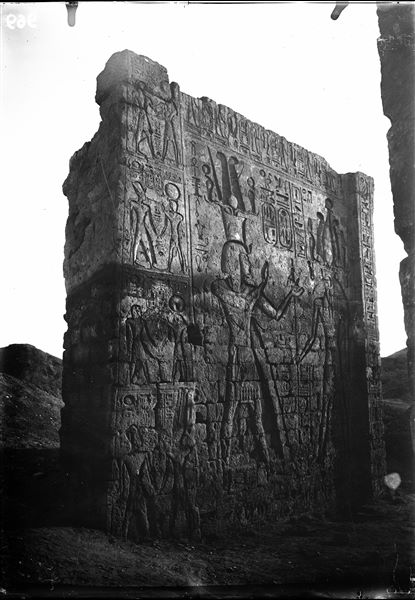 Left side of the entrance portal of the temple of Amun (and Thoth) inside the sacred enclosure of the temple of Thoth. On the left, pharaoh Seti II, on the right, the god Thoth. Photograph taken from outside the temple. Schiaparelli excavations.