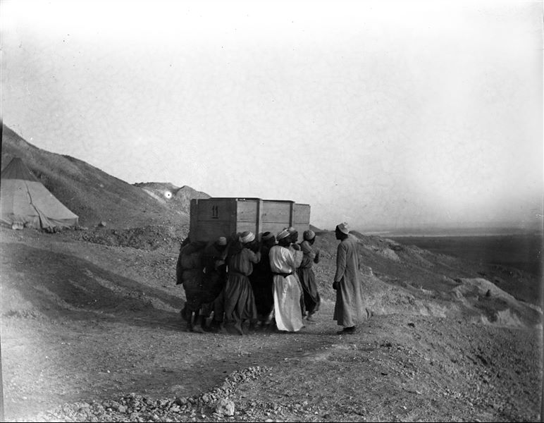 Transporting a crate of the Italian Archaeological Mission from the camp in front of Tomb V; belonging to the governor Khety I. Scavi Schiaparelli.