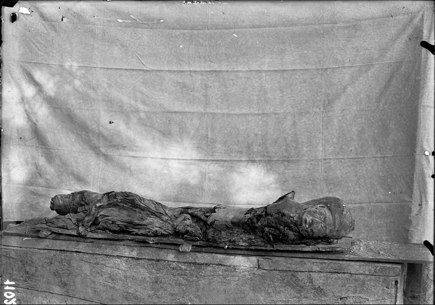 Resti mummificati, con frammenti di tessuto e di cartonnage della defunta Meres (S.08942), fotografati nei pressi dell’accampamento, davanti alla tomba III. Scavi Schiaparelli.