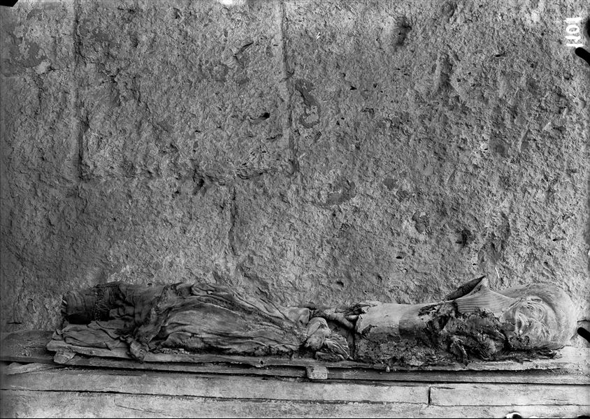 Resti mummificati, con frammenti di tessuto e di cartonnage della defunta Meres (S.08942), fotografati nei pressi dell’accampamento, davanti alla tomba III. Scavi Schiaparelli.