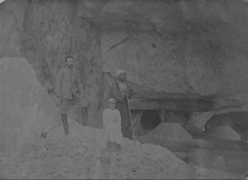 Francesco Ballerini fotografato insieme al rais Kalifa (anch’egli in piedi) e al giovane Buhus, davanti alla grotta che funse da accampamento durante gli scavi della Missione Archeologica Italiana nel 1905 e nel 1906 a Qau el-Kebir e Hammamiya. Archivio Angelo Sesana 