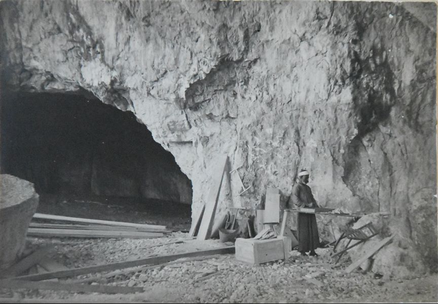 Accampamento della Missione Archeologica Italiana a Qau el-Kebir. La fotografia riprende il falegname Morkos alle prese con la fabbricazione di casse, per il trasporto dei materiali, verso la fine della missione. Archivio Angelo Sesana. 