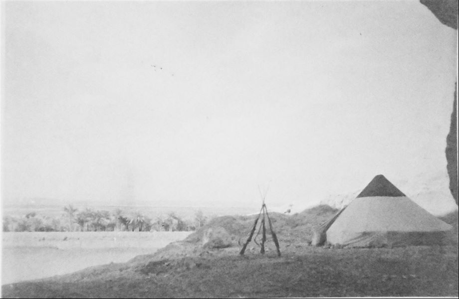 Veduta del paesaggio dall’accampamento della missione italiana a Qau el-Kebir, dove è visibile una tenda conica e un tre fucili. Archivio Angelo Sesana. 