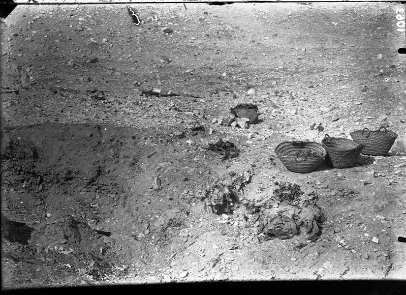 Scene of excavation near the rock-cut tombs, remains of textiles and fragments of vases can be glimpsed. Schiaparelli excavations.