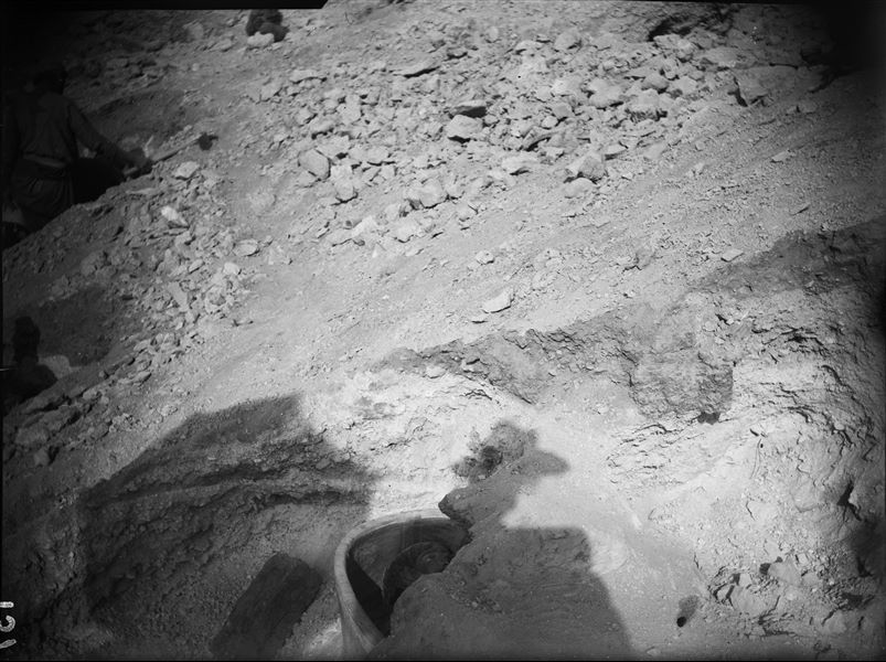 An anthropomorphic sarcophagus in terracotta with a funerary mask emerges from the excavation. Schiaparelli excavations.